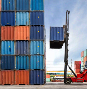 Crane lifting up container in yard